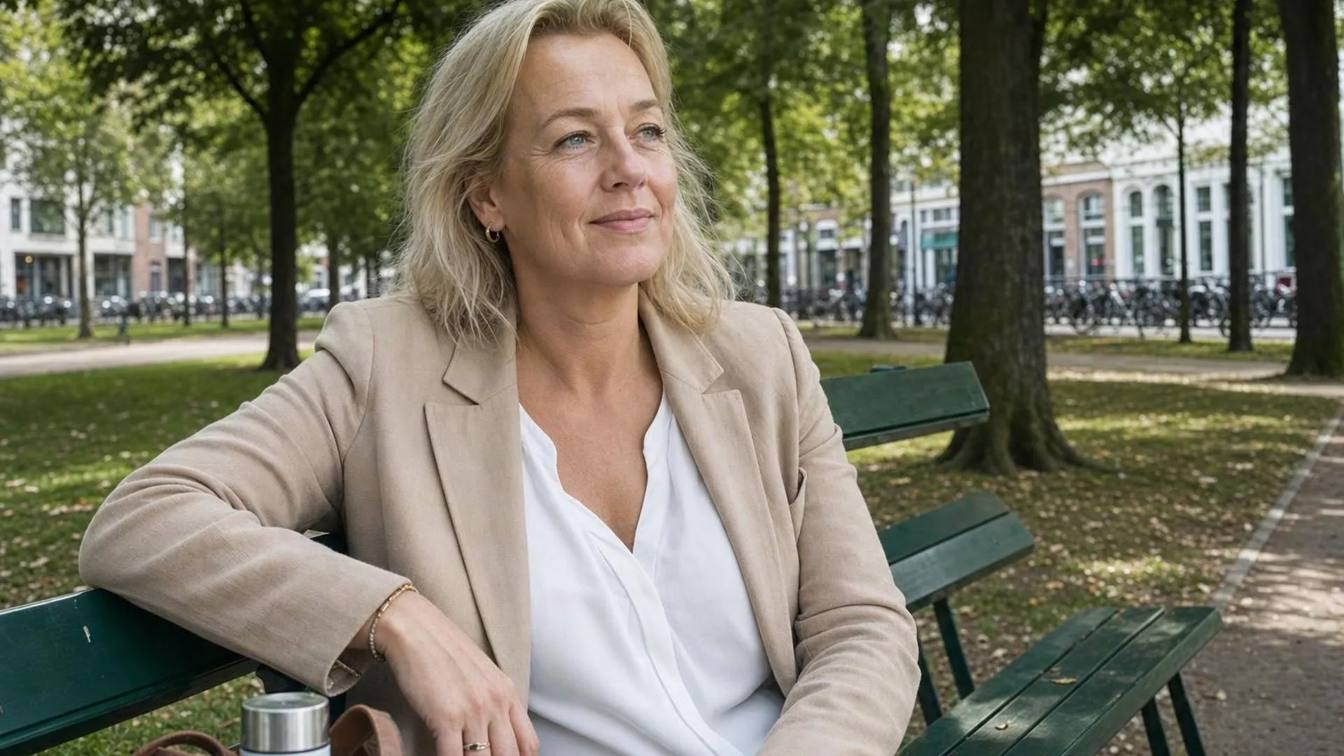 Persoon zit rustig op een bankje in een park tijdens lunchpauze