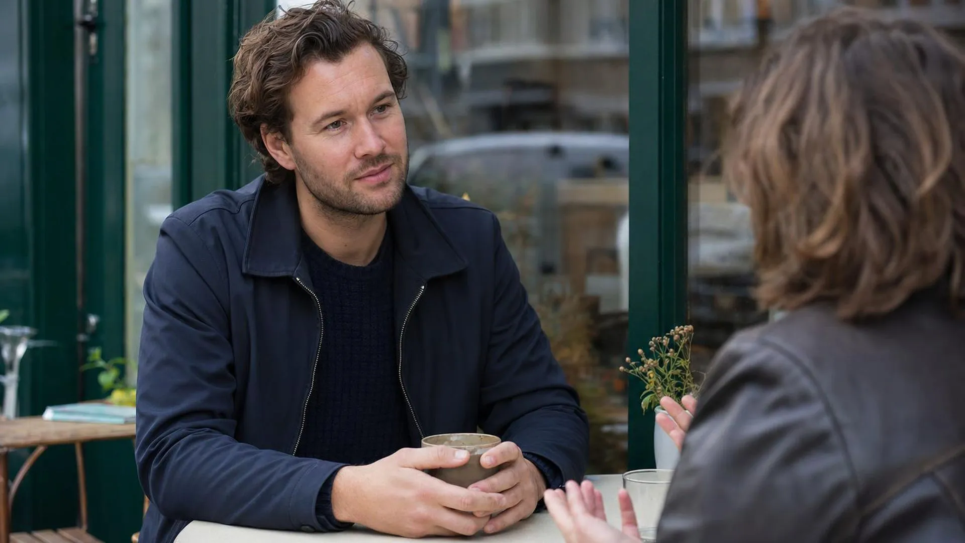 Twee mensen in gesprek aan een cafétafel, vertrouwen en verbinding