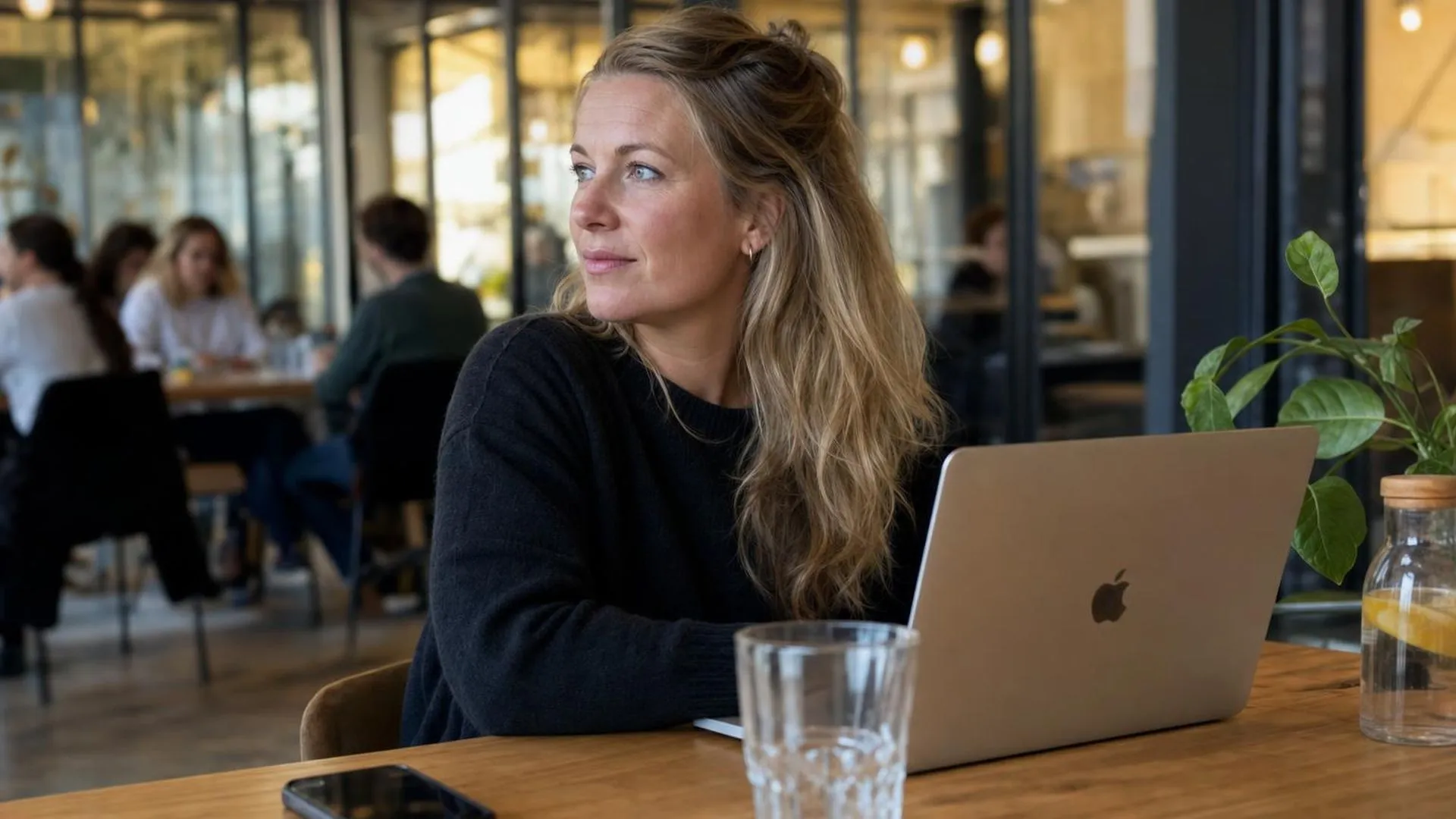 Persoon die even pauzeert op een gedeeld werktafeltje in een koffiebar