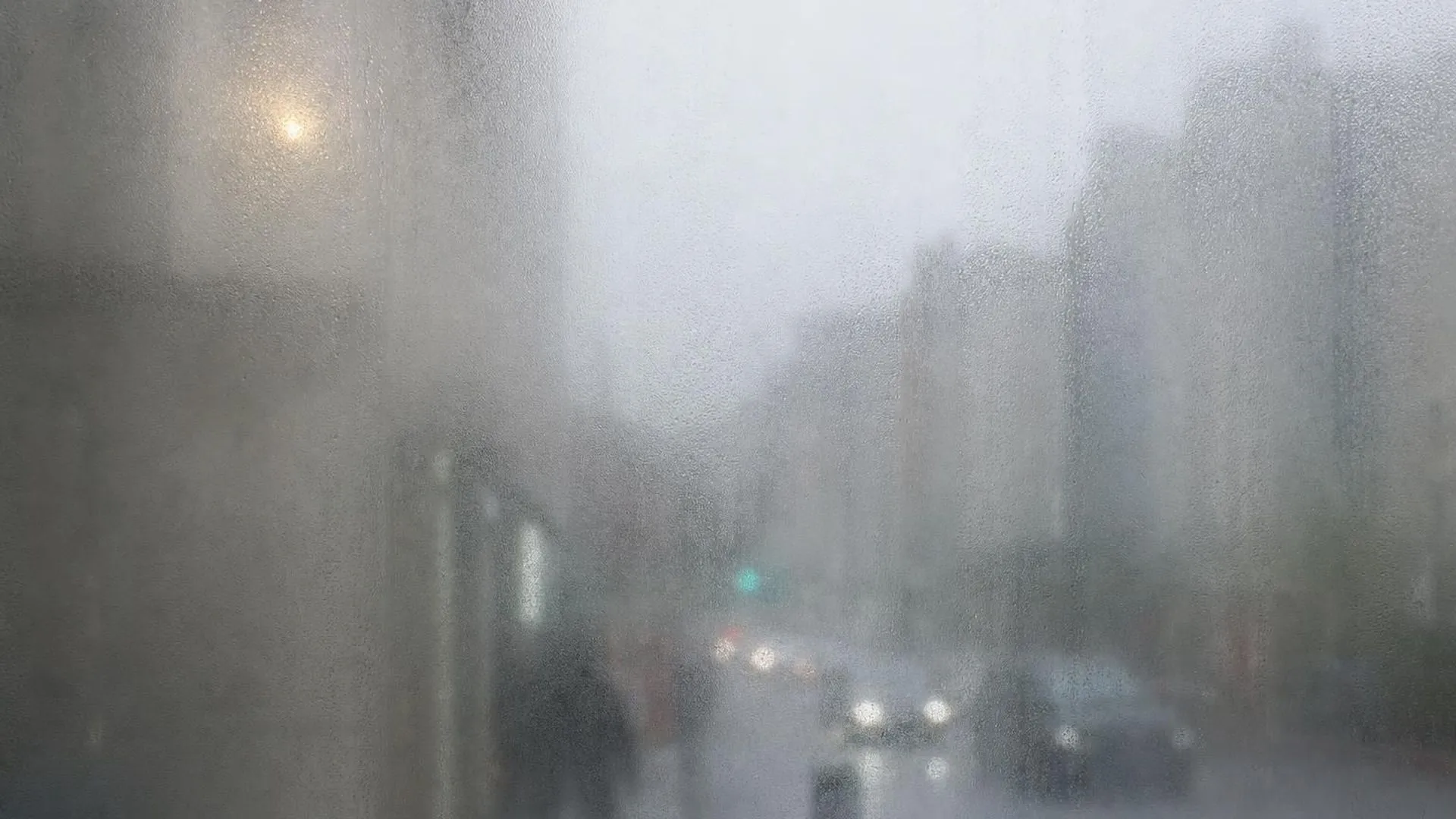 Wazig zicht op een straat, gezien door een beslagen ruit in zacht daglicht
