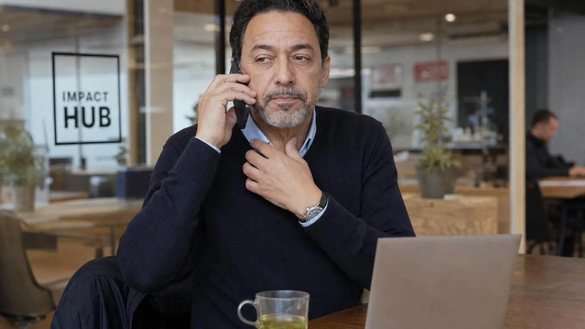 Persoon pauzeert tijdens een telefoongesprek in een koffiebar