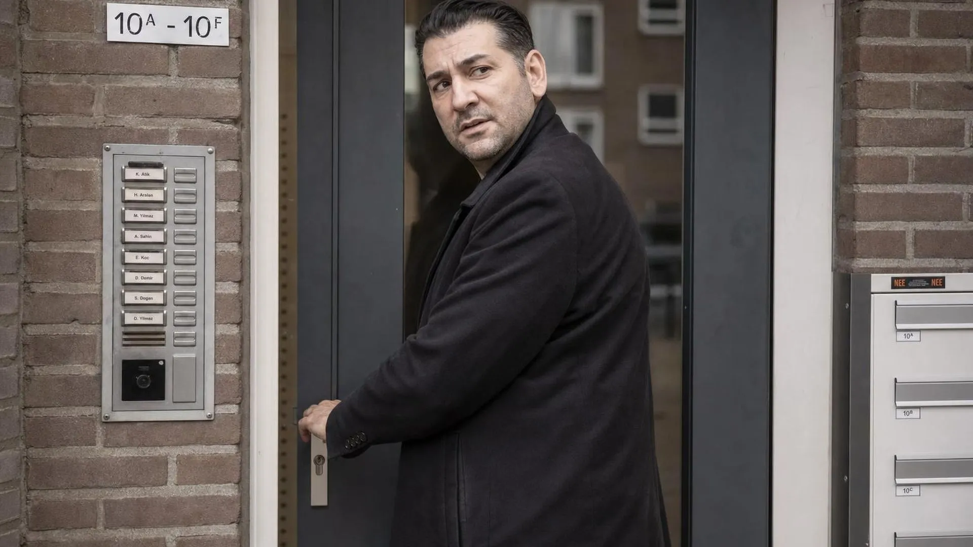 Iemand die bij de voordeur twijfelt of die wel op slot zit