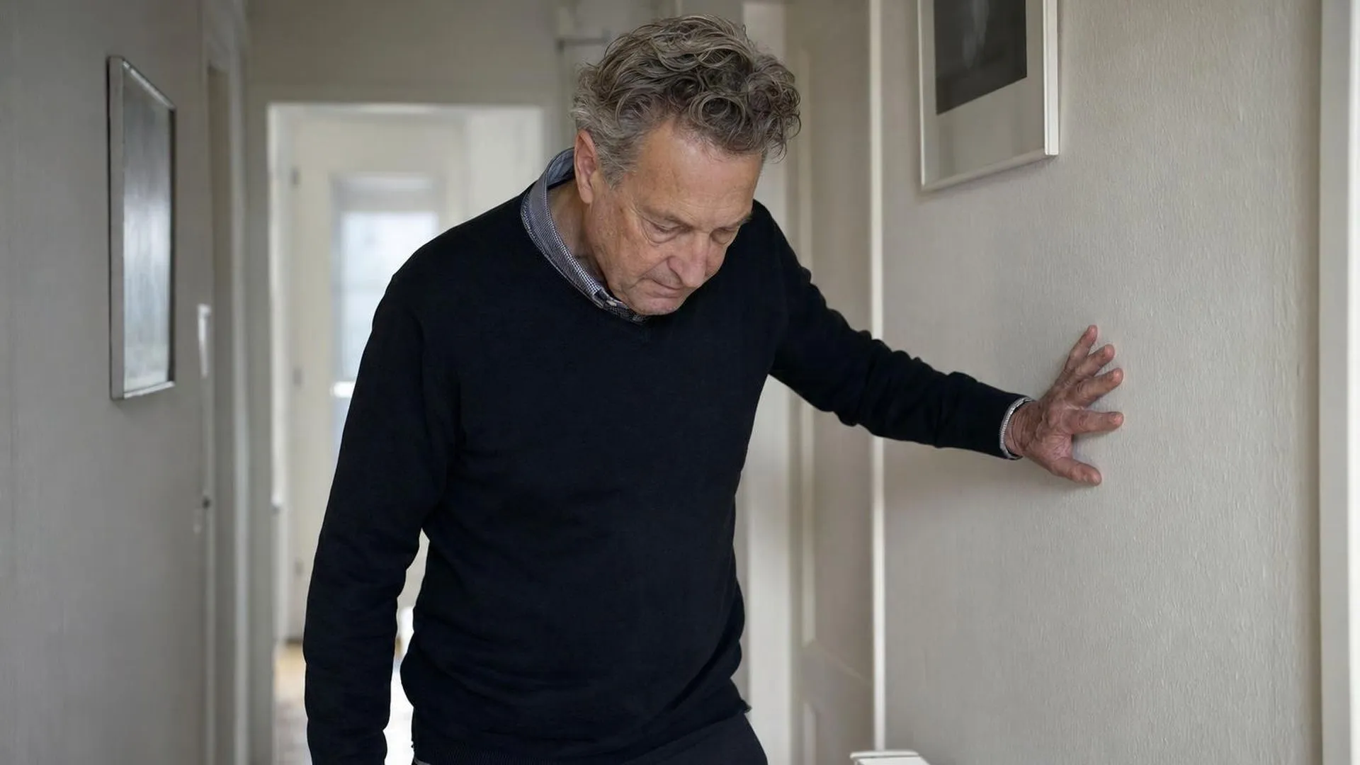 Persoon leunt even tegen de muur, overweldigd door emoties bij burn-out