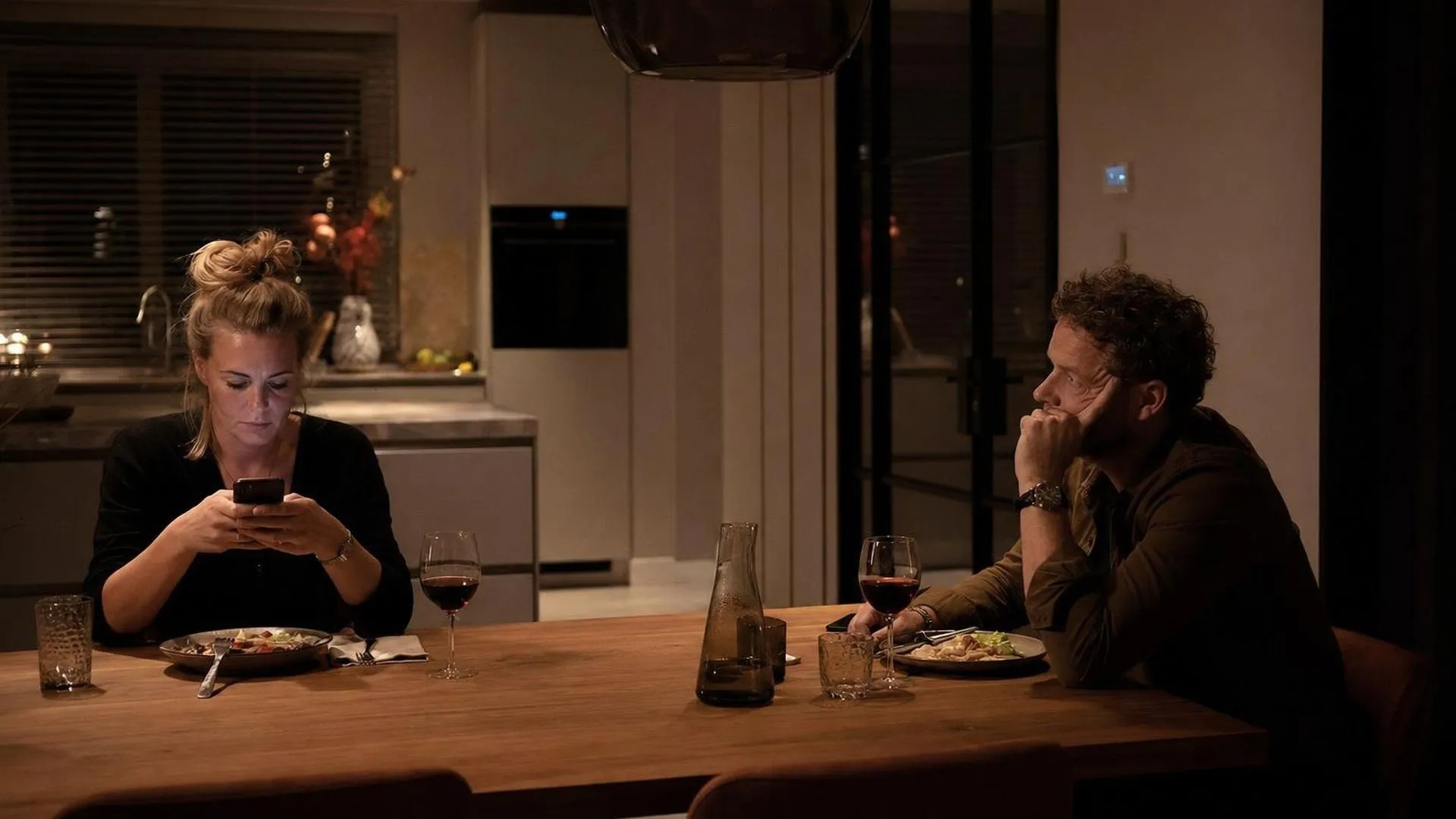 Persoon voelt zich eenzaam naast emotioneel onbereikbare partner aan tafel