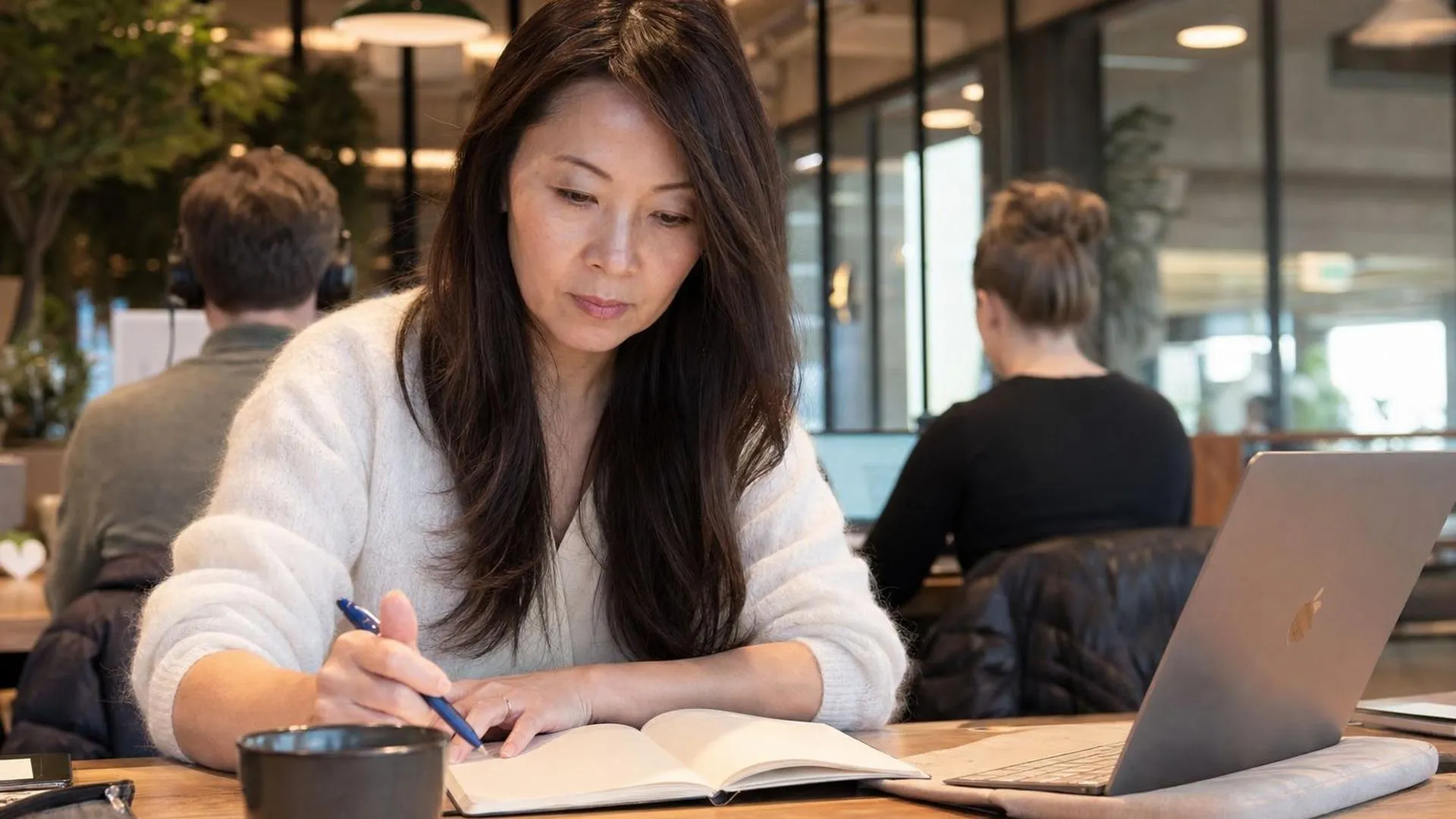 Persoon staart naar een notitieboek in een co-working café, verlies van focus door stress