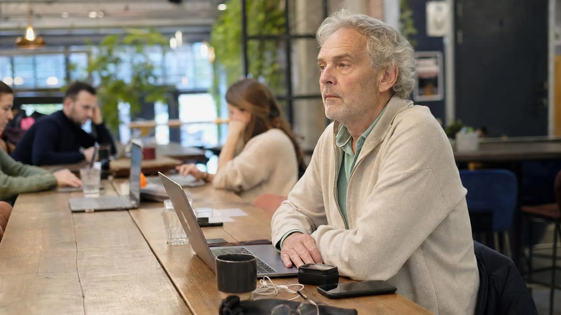 Persoon staart afwezig voor zich uit aan een werktafel