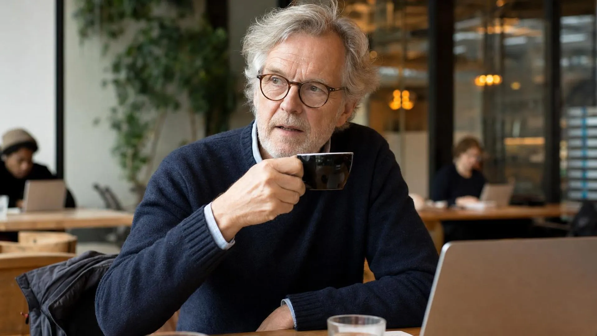 Persoon die nadenkend pauzeert tijdens een gesprek in een café