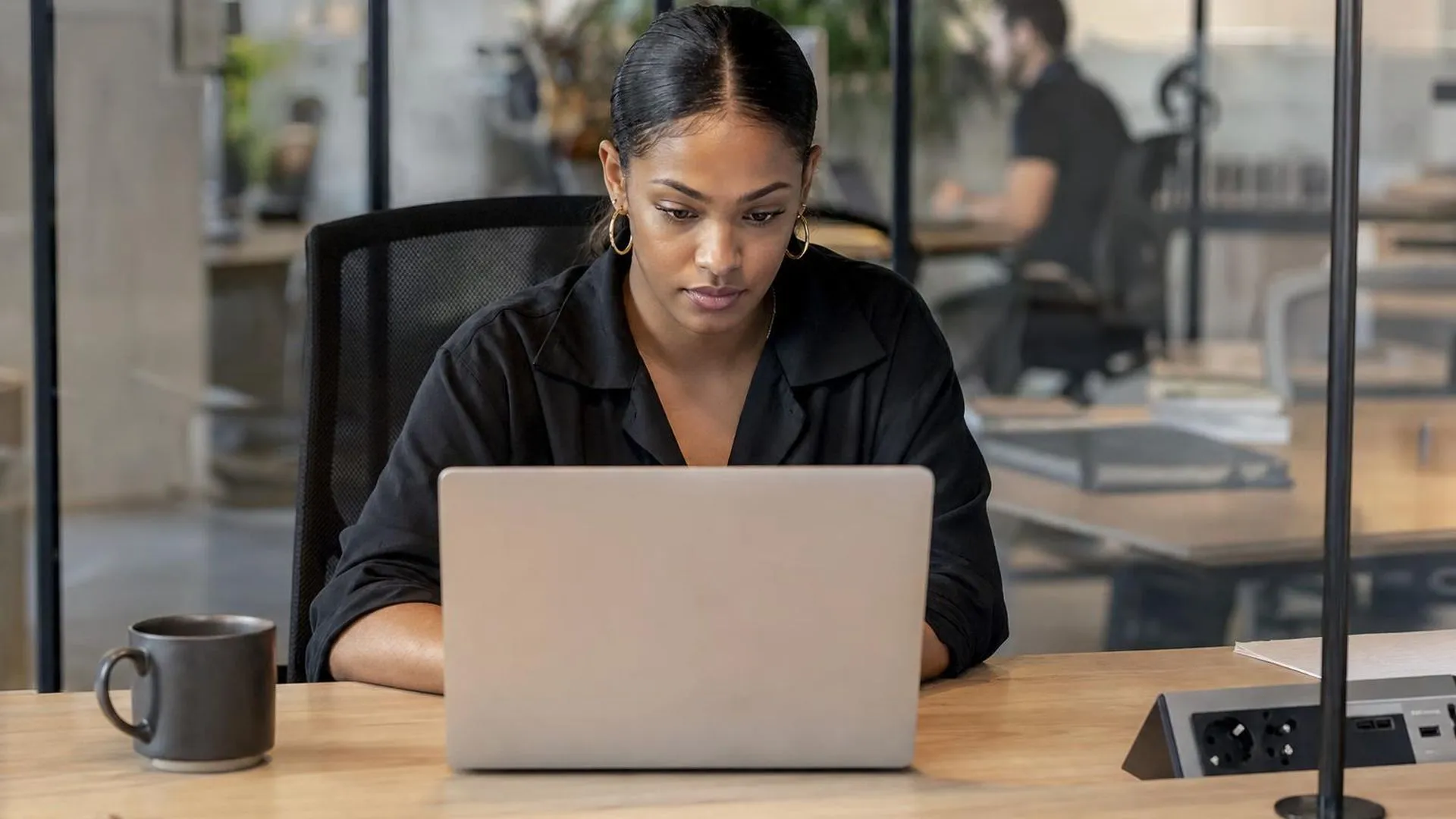 Iemand die verveeld naar een laptopscherm staart op kantoor
