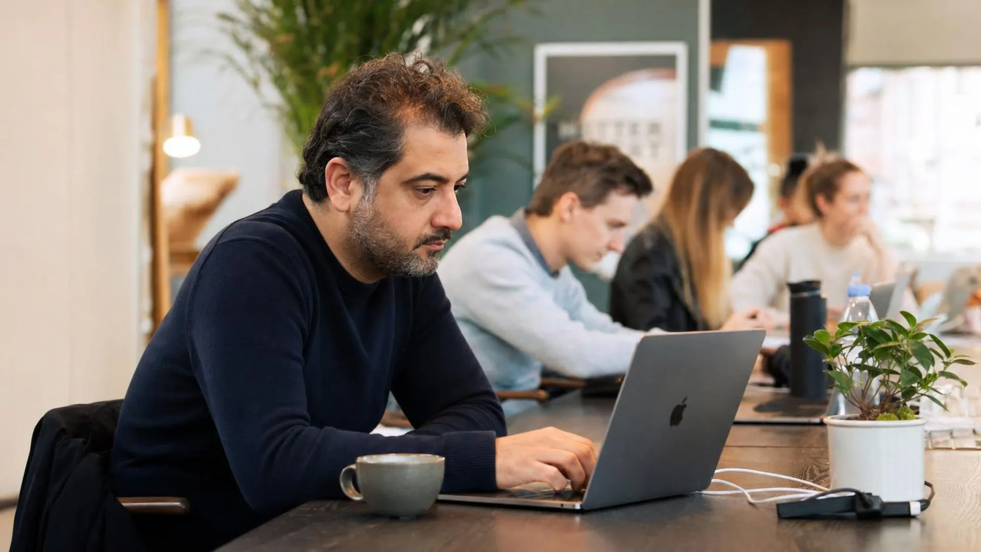 Medewerker staart naar scherm op drukke werkplek zonder pauze te nemen