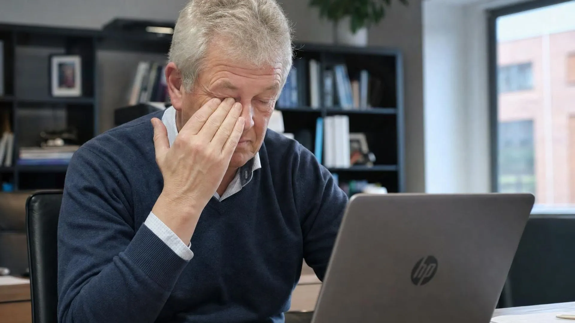 Persoon die moeite heeft met concentreren achter een laptop, een teken van overspanning