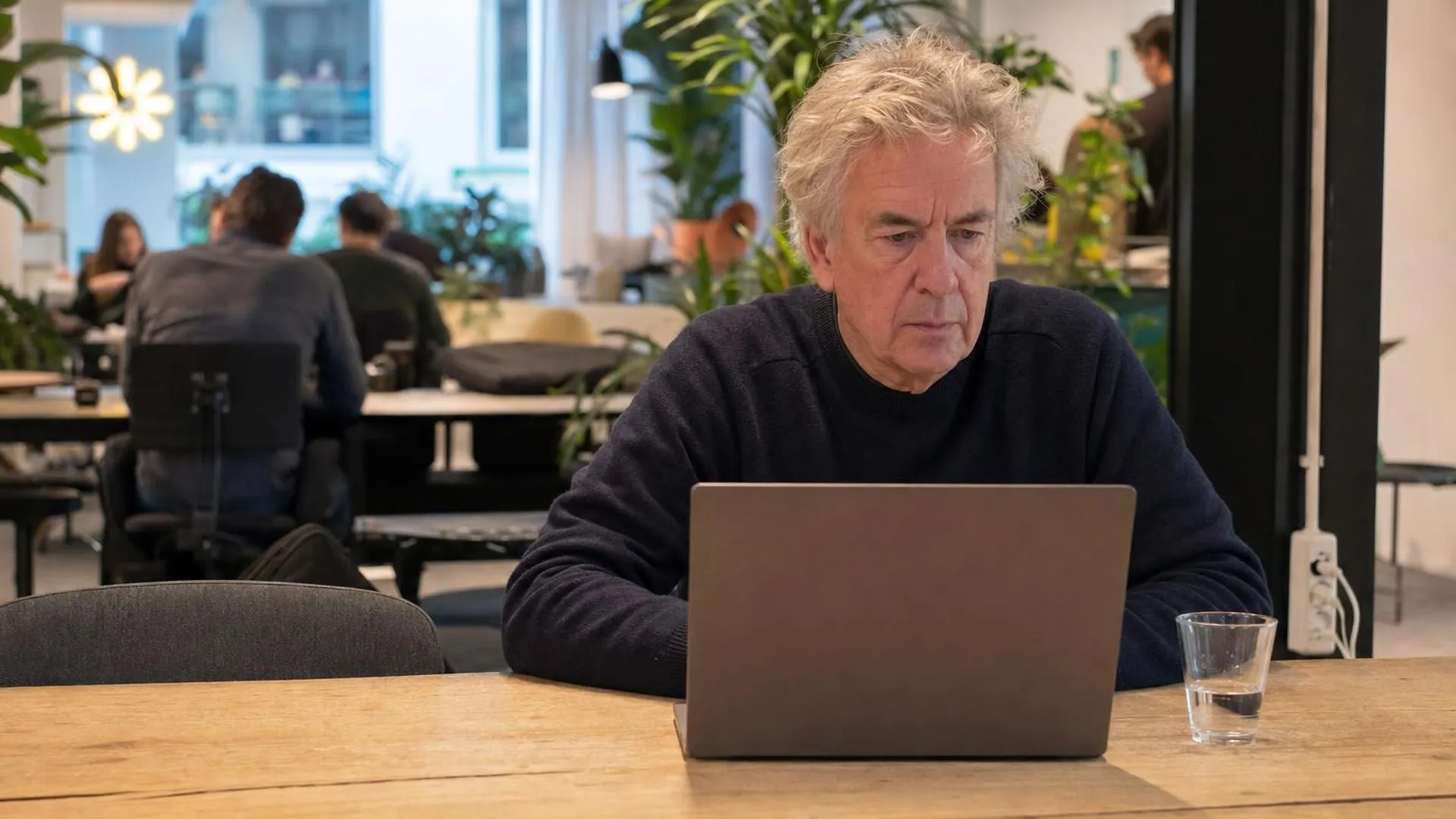 Persoon met energiedip achter laptop in café