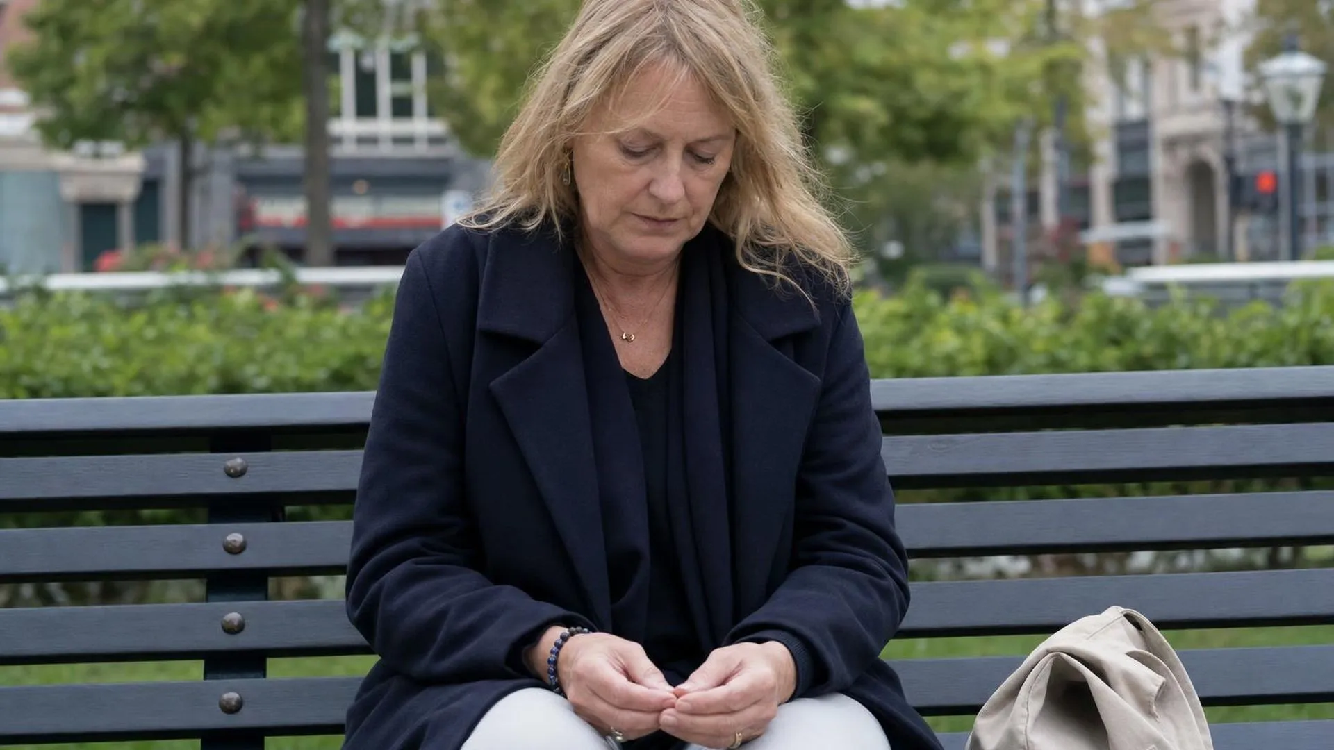 Persoon op bankje in park, even op adem komend tijdens wandeling bij burn-out herstel