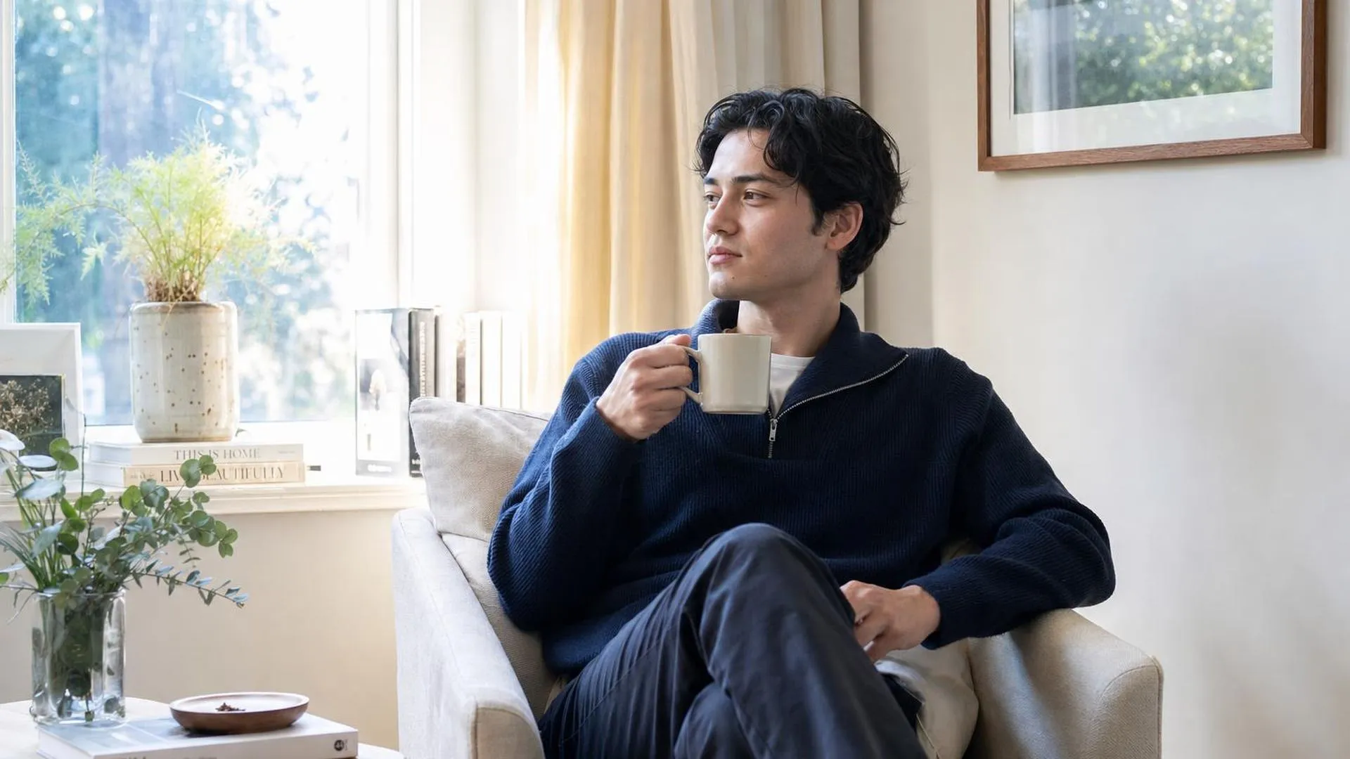Persoon die rustig zit in een stille kamer met een kop thee