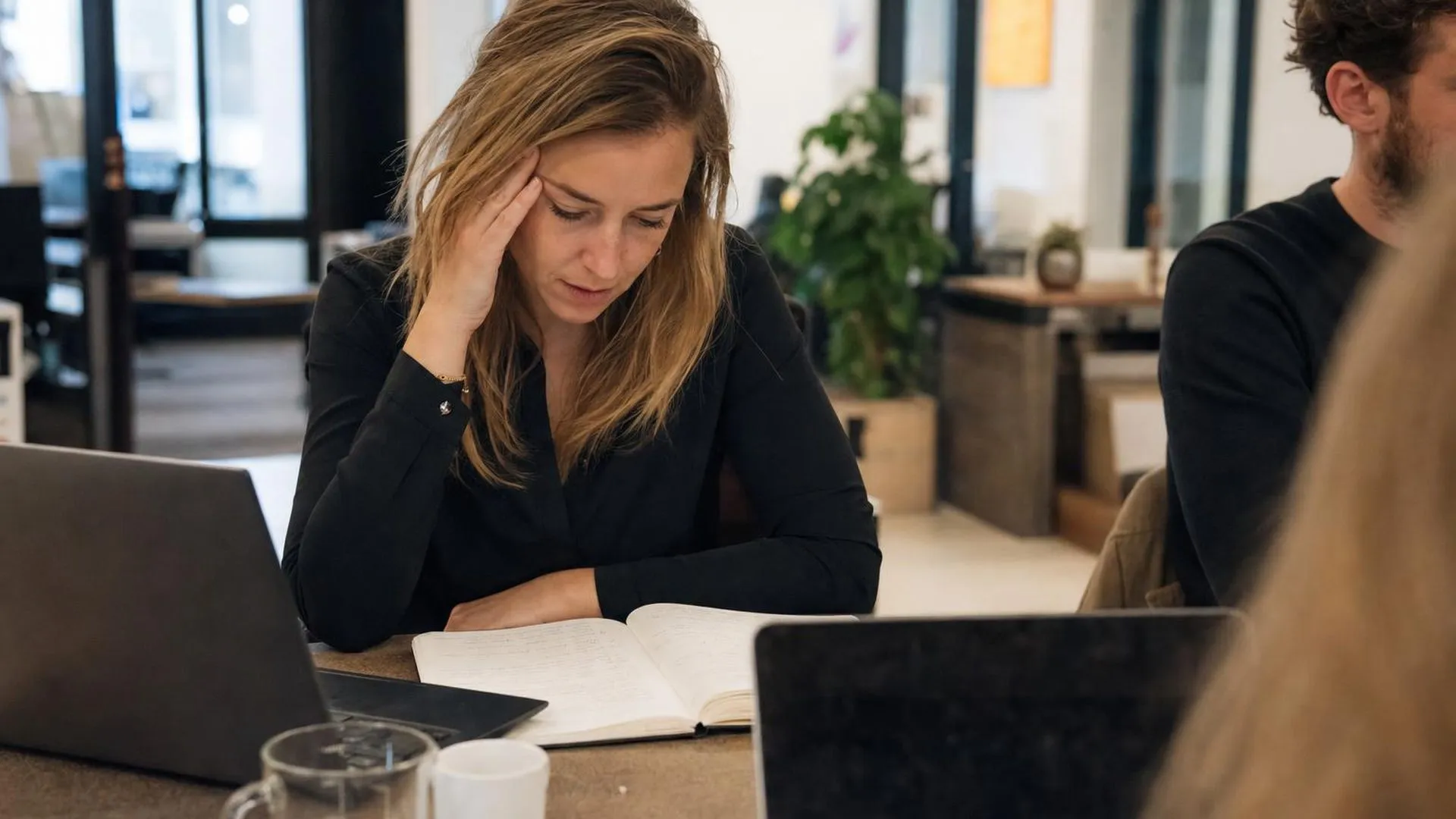 Persoon met hoofdpijn door stress op kantoor