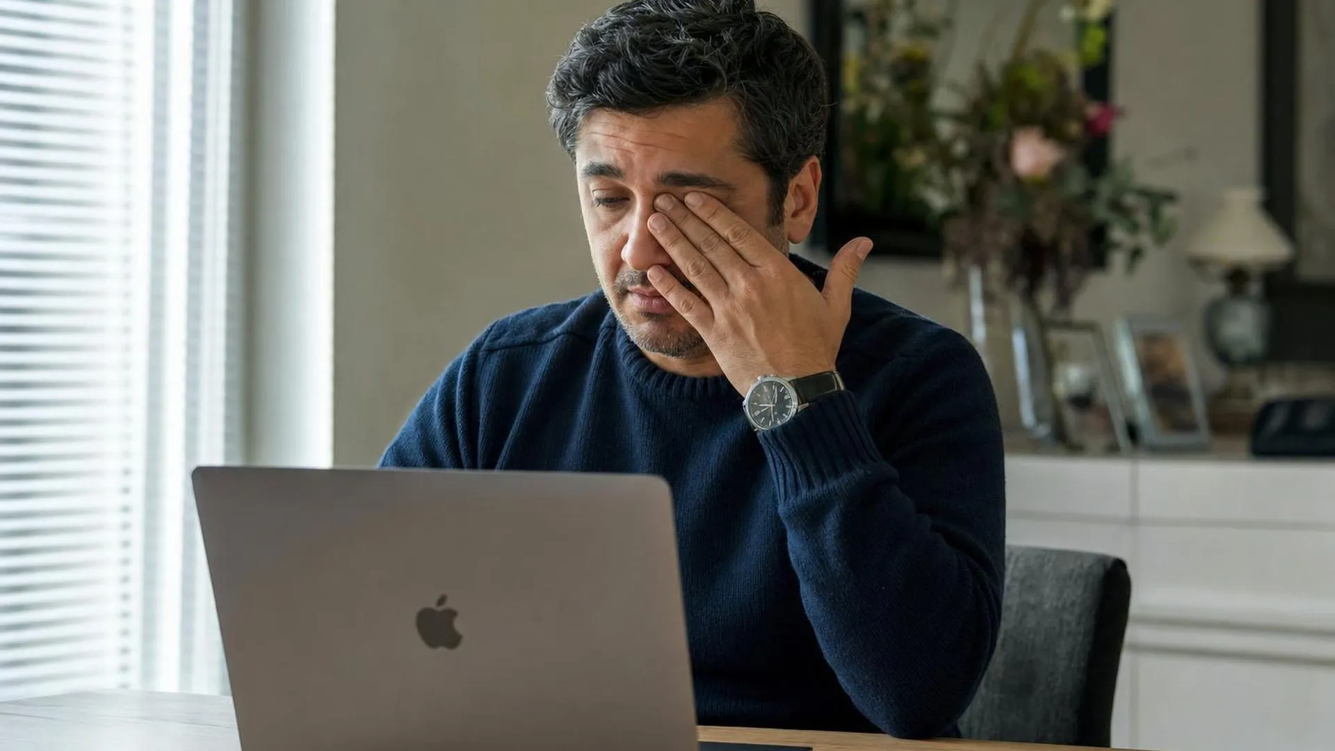 Persoon wrijft in oog bij het kijken naar een laptopscherm